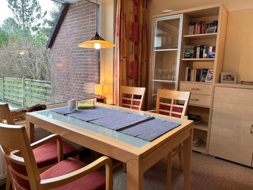 a dining room table with chairs and a window at Küsten Koje in Sankt Peter-Ording