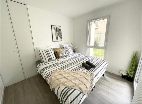 - une chambre dotée d'un lit avec un oreiller noir dans l'établissement Appartement - Le Salengro, à Villeurbanne