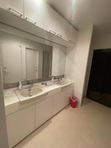 a bathroom with two sinks and a large mirror at Tokyo Shibya 88 Shared House in Tokyo