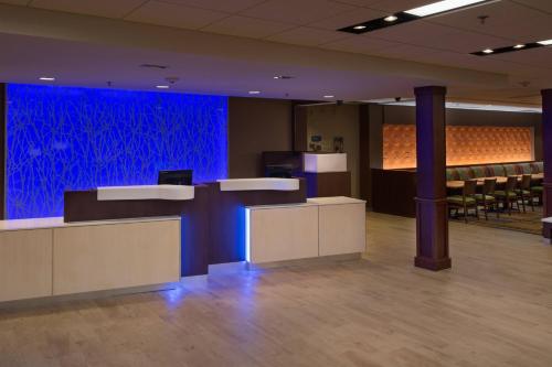 a lobby with a blue wall and tables and chairs at Fairfield Inn & Suites by Marriott Houma Southeast in Houma