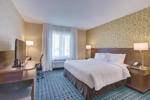 a hotel room with a bed and a flat screen tv at Fairfield Inn & Suites By Marriott Wichita East in Wichita