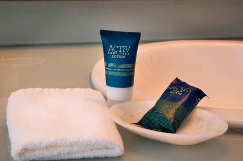 a sink with a bottle of toothpaste and a towel at Four Points by Sheraton Queretaro Norte in Querétaro
