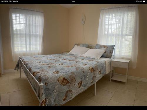 un letto in una camera da letto con due finestre di Charming 3 Bedroom 2 Bathroom and a lanai a Venice