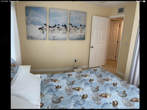 una camera da letto con un letto con quattro dipinti sul muro di Charming 3 Bedroom 2 Bathroom and a lanai a Venice