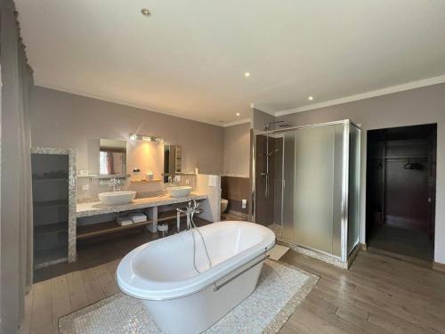 La grande salle de bains est pourvue d'une baignoire et de deux lavabos. dans l'établissement Domaine de la Clapière, à Montagnac