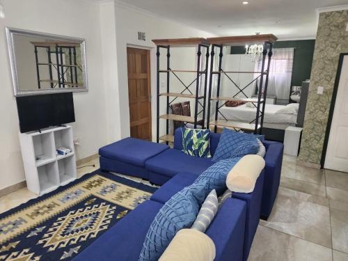 ケープタウンにあるTia Maria bachelor apartmentのリビングルーム(青いソファ、二段ベッド付)