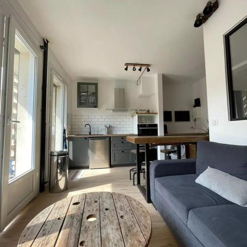 - un salon avec un canapé bleu et une table en bois dans l'établissement FLC - Charming Studio Parking - 4 Guests, à Marseille
