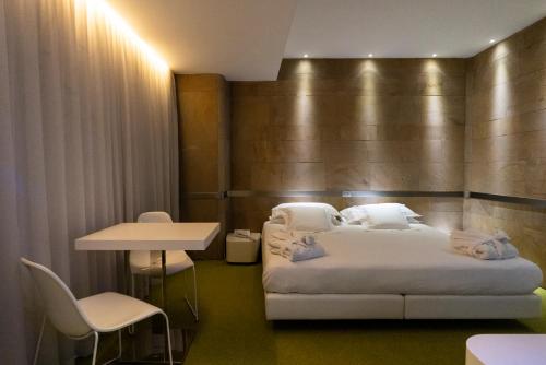 a hotel room with a bed and a table and chairs at A Point Arezzo Park Hotel in Arezzo