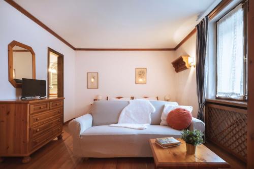 a living room with a couch and a table at GuestHost - Cortina Heart Retreat with Parking in Cortina dʼAmpezzo