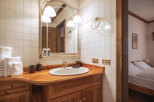 a bathroom with a sink and a mirror at GuestHost - Cortina Heart Retreat with Parking in Cortina dʼAmpezzo