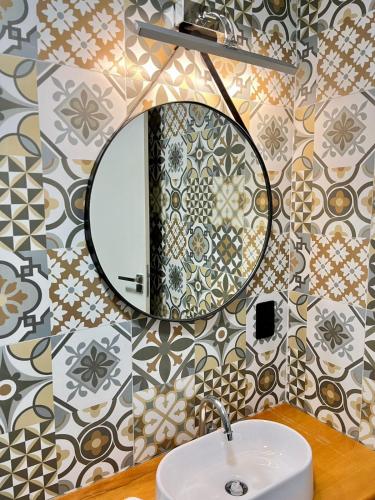 a bathroom with a sink and a mirror on a wall at Santa Rita Pousada in Guarujá