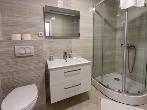 a bathroom with a toilet and a shower and a sink at Apartments Leo in Bar