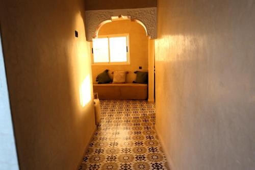 a hallway with a tile floor with a window and a couch at Little Beach House Sidi Kaouki in Sidi Kaouki