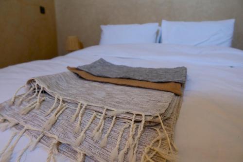 ein Bett mit einer Decke darüber in der Unterkunft Little Beach House Sidi Kaouki in Sidi Kaouki