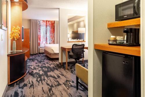 a hotel room with a desk and a bed and a room at Fairfield Inn & Suites Minneapolis Eden Prairie in Eden Prairie