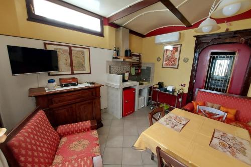 a living room with a red couch and a kitchen at Relax Rurale in Fienile Nuovo Malea