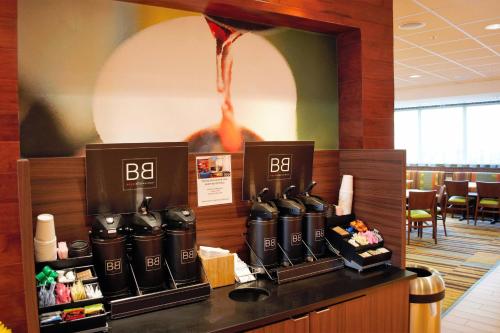 a restaurant with a bar with a row of black gasemen at Fairfield Inn & Suites by Marriott Stroudsburg Bartonsville/Poconos in Stroudsburg