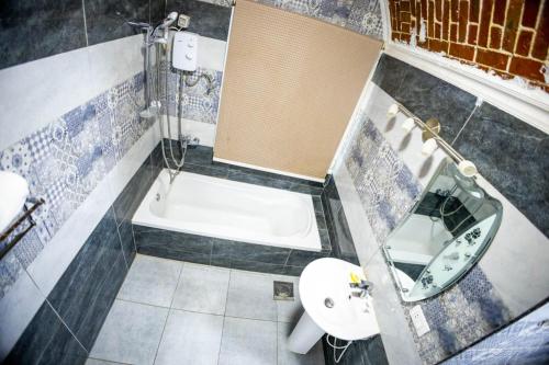 a bathroom with a tub and a sink and a toilet at Andalusia Blue Beach Hurghada in Hurghada