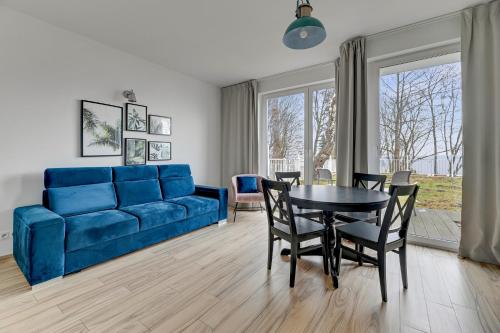 a living room with a blue couch and a table at Orłowska Riwiera - Blue Mandarin Apartments in Gdynia