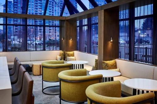 a restaurant with tables and chairs and windows at Delta Hotels by Marriott Toronto Mississauga in Mississauga