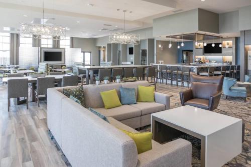 a living room with a couch and tables and a kitchen at Fairfield Inn & Suites by Marriott San Jose North/Silicon Valley in San Jose