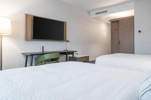 a hotel room with two beds and a desk with a tv at Fairfield Inn & Suites by Marriott San Jose North/Silicon Valley in San Jose
