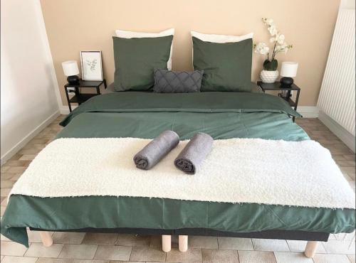 - un lit vert avec 2 oreillers dans l'établissement Apartment - Le Melies, à Villeurbanne