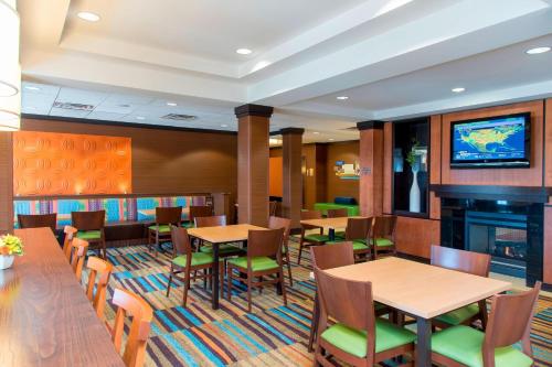 a restaurant with tables and chairs and a fireplace at Fairfield Inn & Suites by Marriott Omaha Downtown in Omaha