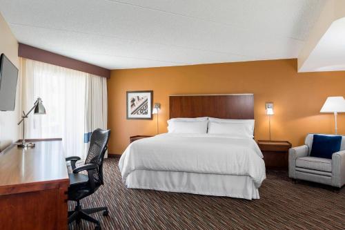a hotel room with a bed and a desk and a chair at Four Points by Sheraton Buffalo Grove in Buffalo Grove