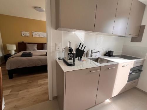a kitchen with a sink and a bed in a room at UP&GREAT Apartments - Stylish City Living in Zürich