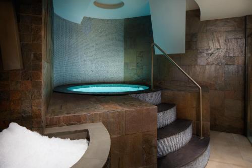 a bathroom with a hot tub on a set of stairs at Four Points by Sheraton Prishtina City in Pristina