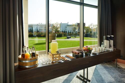 a bar with drinks and snacks in front of a window at Four Points by Sheraton Prishtina City in Pristina