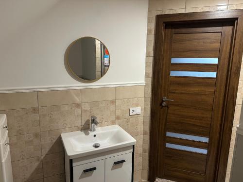 a bathroom with a sink and a mirror at D&R Apartments in Mažeikiai