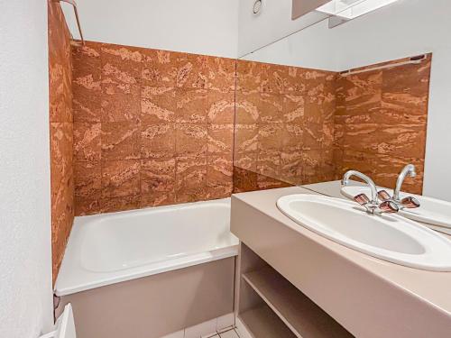 une salle de bain avec un lavabo et une baignoire dans l'établissement Bord de mer, balcon, à deux pas des commerces, à La Grande Motte