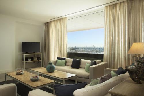 a living room with a couch and a large window at Suites Puerto Sherry in El Puerto de Santa María