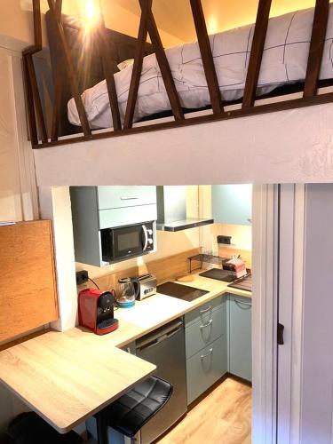 a small kitchen with a bed on top of it at Magnolia Home in Caen
