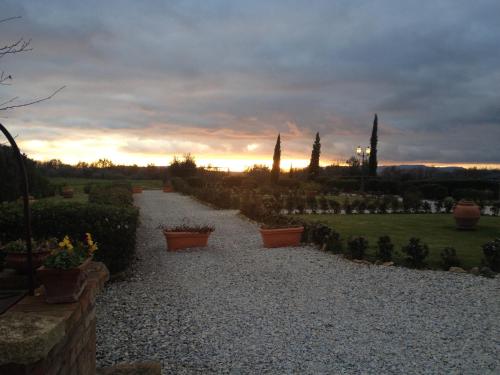 a view of a garden with a sunset in the background at Agriturismo Il Macchione in Pienza