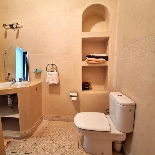 a bathroom with a toilet and a sink at Azure Horizon Villa Club evasion in Sidi Boulfdail