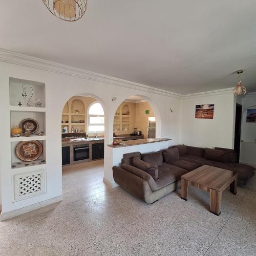 a living room with a couch and a table at Azure Horizon Villa Club evasion in Sidi Boulfdail