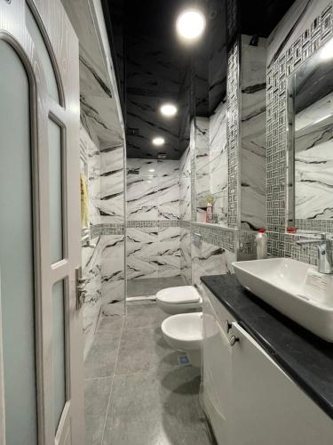 a bathroom with two toilets and a sink at Luxury Apartment Pekini in Tbilisi City