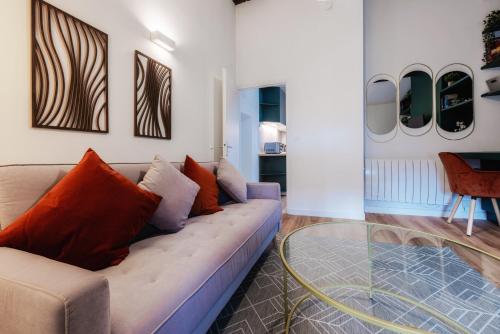 un salon avec un canapé et une table en verre dans l'établissement OIQIA • Stanislas, à Nancy