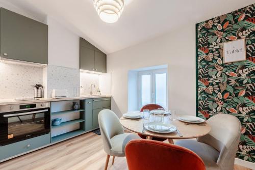 une cuisine et une salle à manger avec une table et des chaises dans l'établissement OIQIA • Stanislas, à Nancy