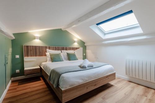 une chambre avec un grand lit avec une lucarne dans l'établissement OIQIA • Stanislas, à Nancy