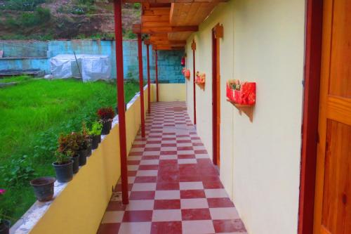 a hallway of a house with a checkered floor at Durgesh Hillock in Rānīkhet