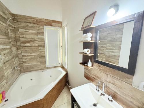 a bathroom with a bath tub and a sink at Cabañas bahia in Bahía Blanca