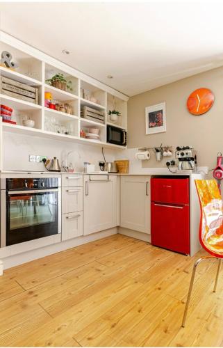 a kitchen with white cabinets and a red drawer at The Condo Swimming Pool available from May until October only in Broadmayne