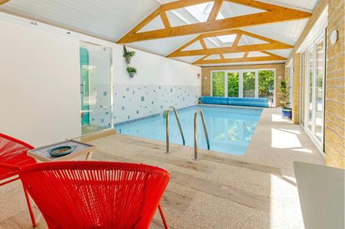 a swimming pool in a house with a red chair at The Condo Swimming Pool available from May until October only in Broadmayne