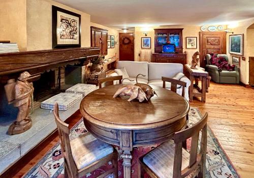 a living room with a table and a fireplace at La Maison de La Moletta in Courmayeur