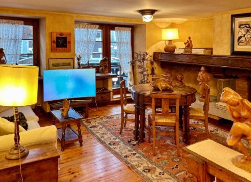 a living room with a table and a fireplace at La Maison de La Moletta in Courmayeur