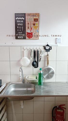 a kitchen counter with a sink and utensils at Friday Homestay Taman Sawit Balung, Tawau in Tawau